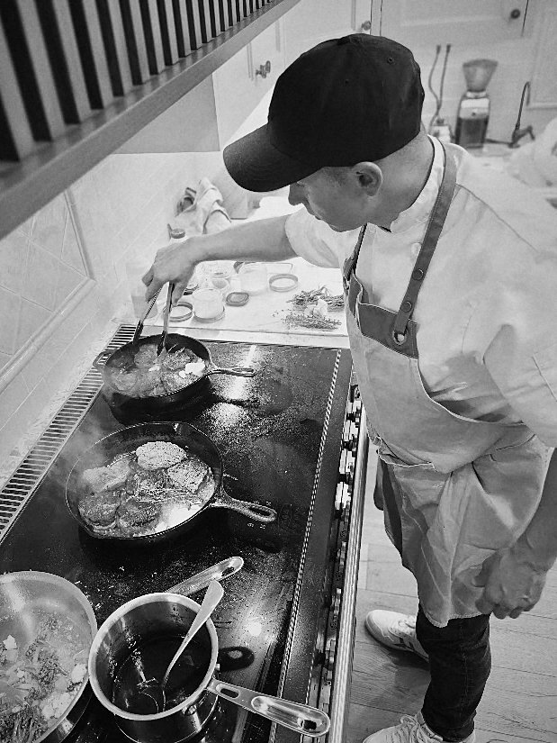 Boyan searing steaks and finishing a sauce at the range
