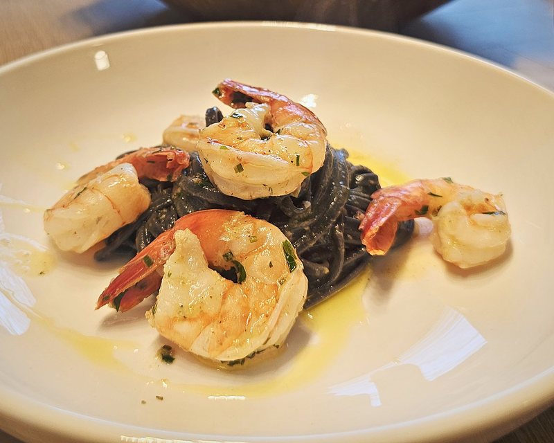 Squid ink spaghetti with garlic-butter prawns